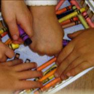 Children's hands grabbing crayons